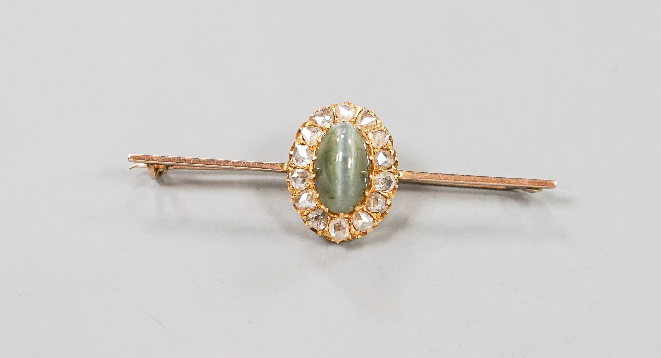 A yellow metal cat's eye chrysoberyl and rose cut diamond set bar brooch, 62mm, gross weight 6 grams.